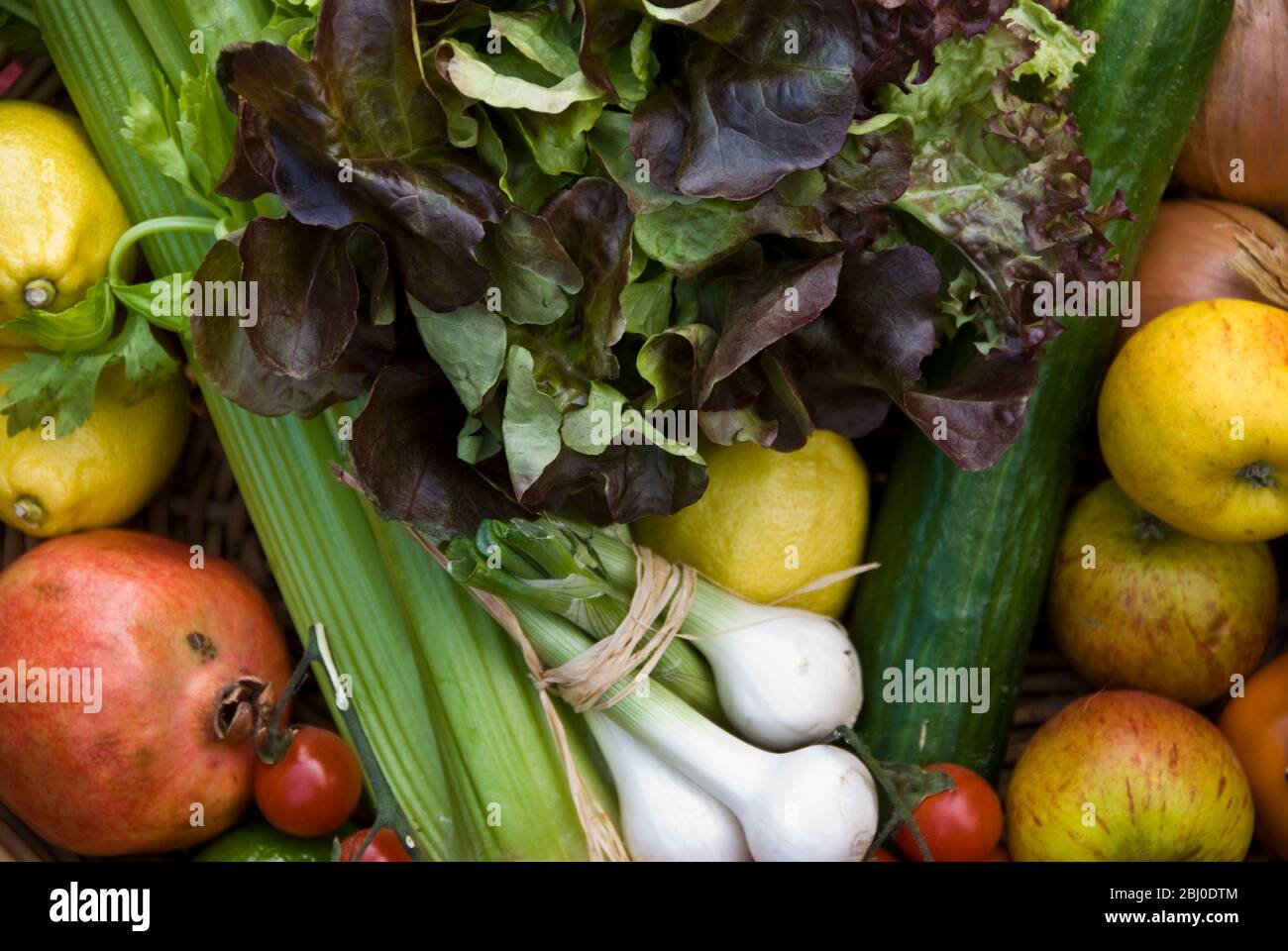 Panier de fruits et légumes frais sur la surface rouge - Banque D'Images