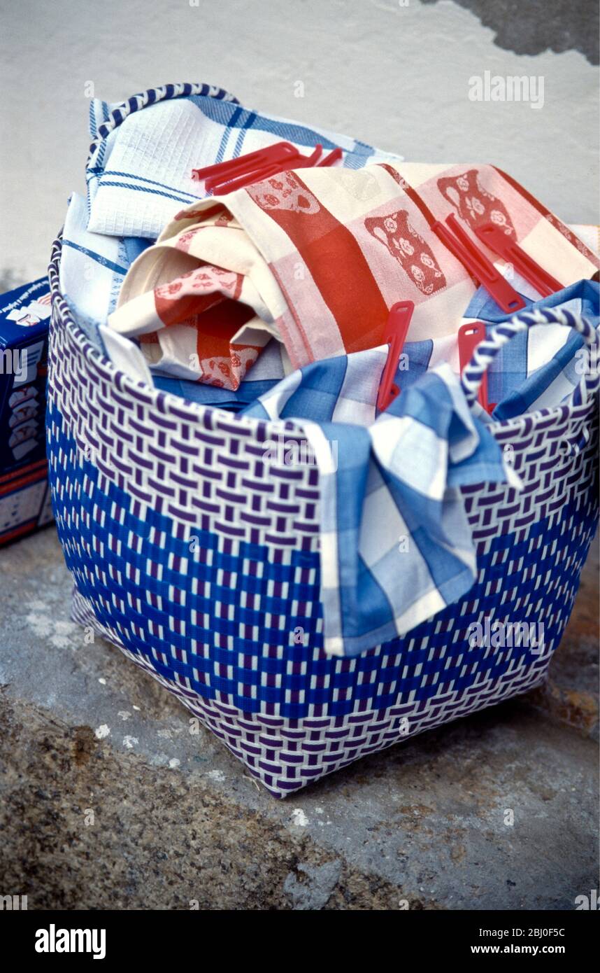 Piles de lavage dans le panier de linge tissé en plastique sur l'ancienne étape en pierre - Banque D'Images
