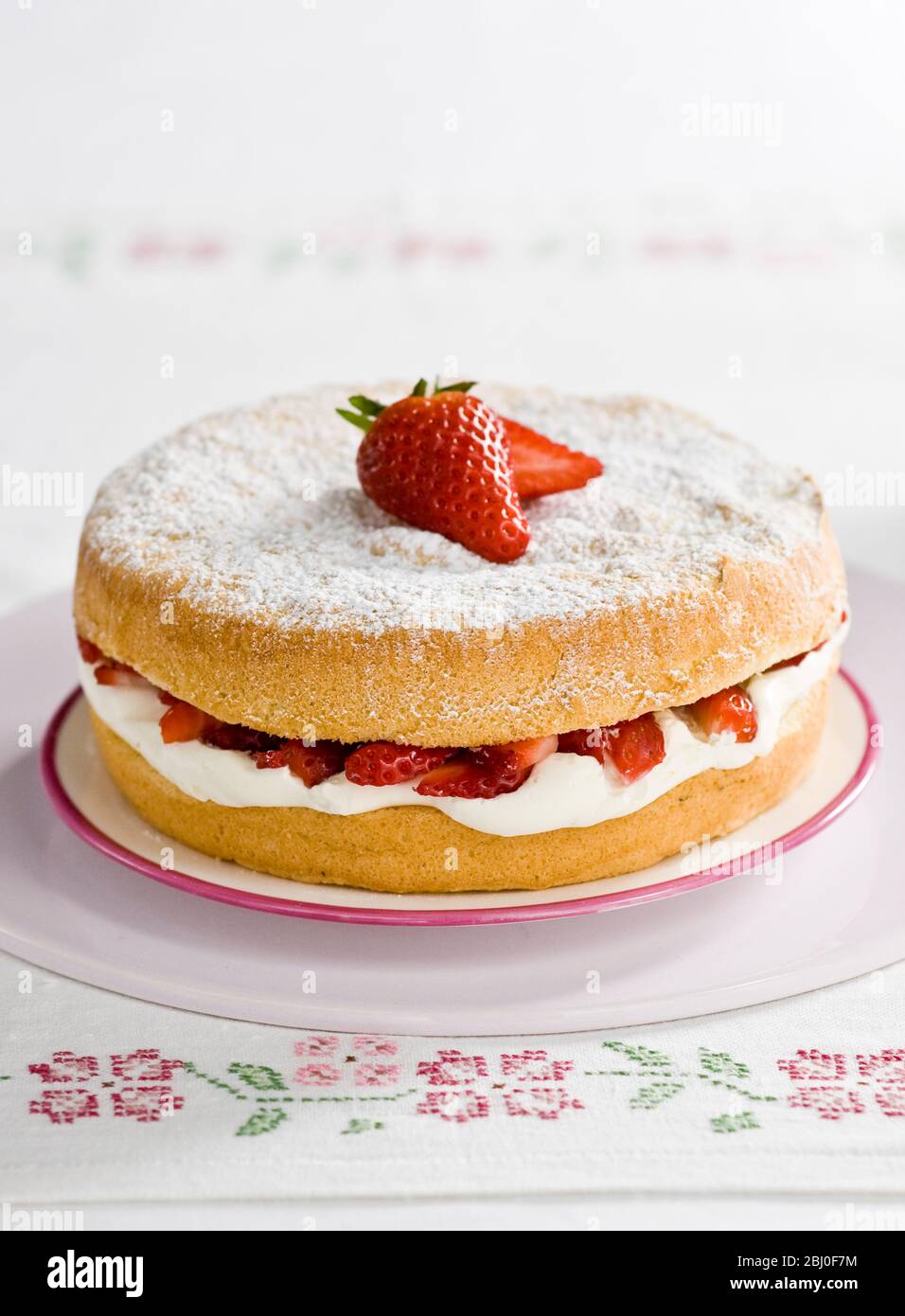Gâteau éponge américain avec crème fouettée et fraises - Banque D'Images