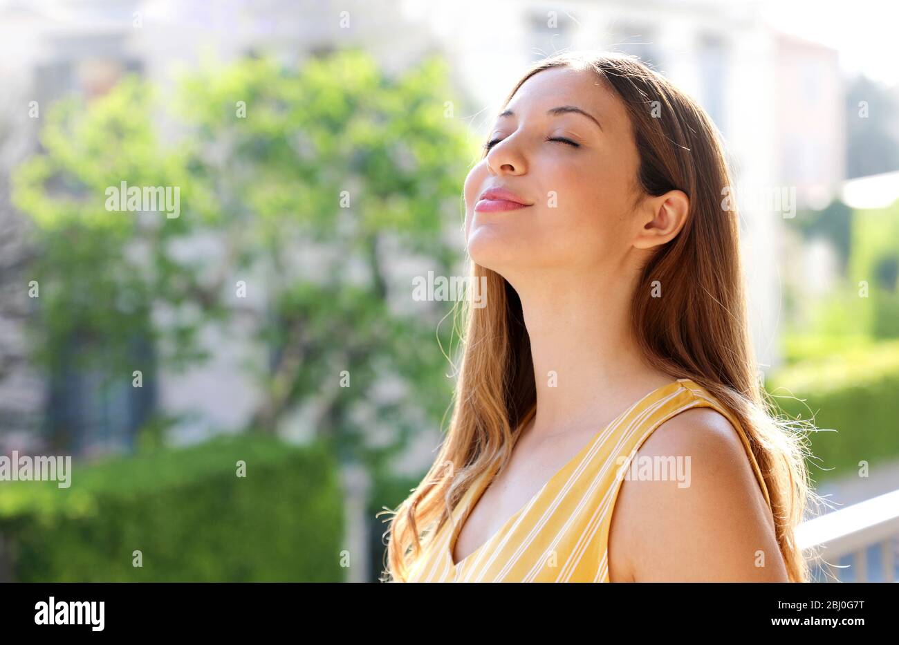 Une jeune femme détendue respirait l'air frais sur le balcon le matin Banque D'Images