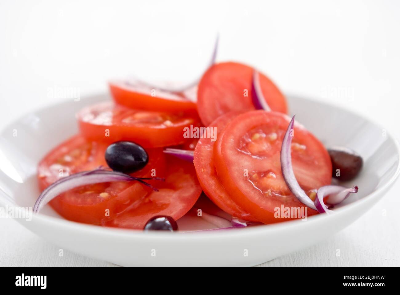 Salade de tomates avec oignon rouge et olives noires - Banque D'Images