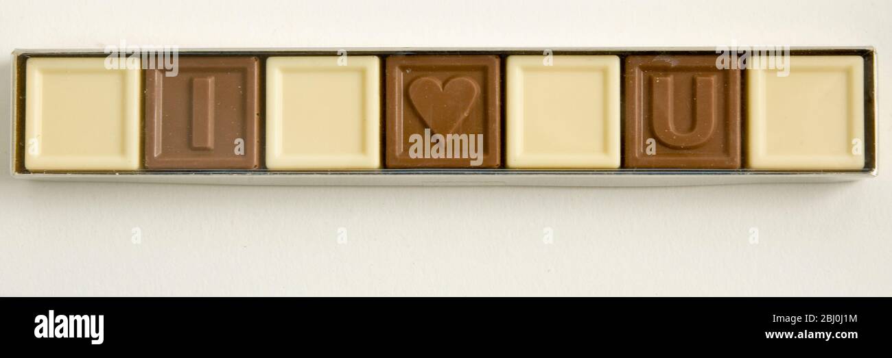 Lettres au chocolat qui orthographient « Je T'AIME » dans la boîte de cellophane comme cadeau de Saint-Valentin - Banque D'Images