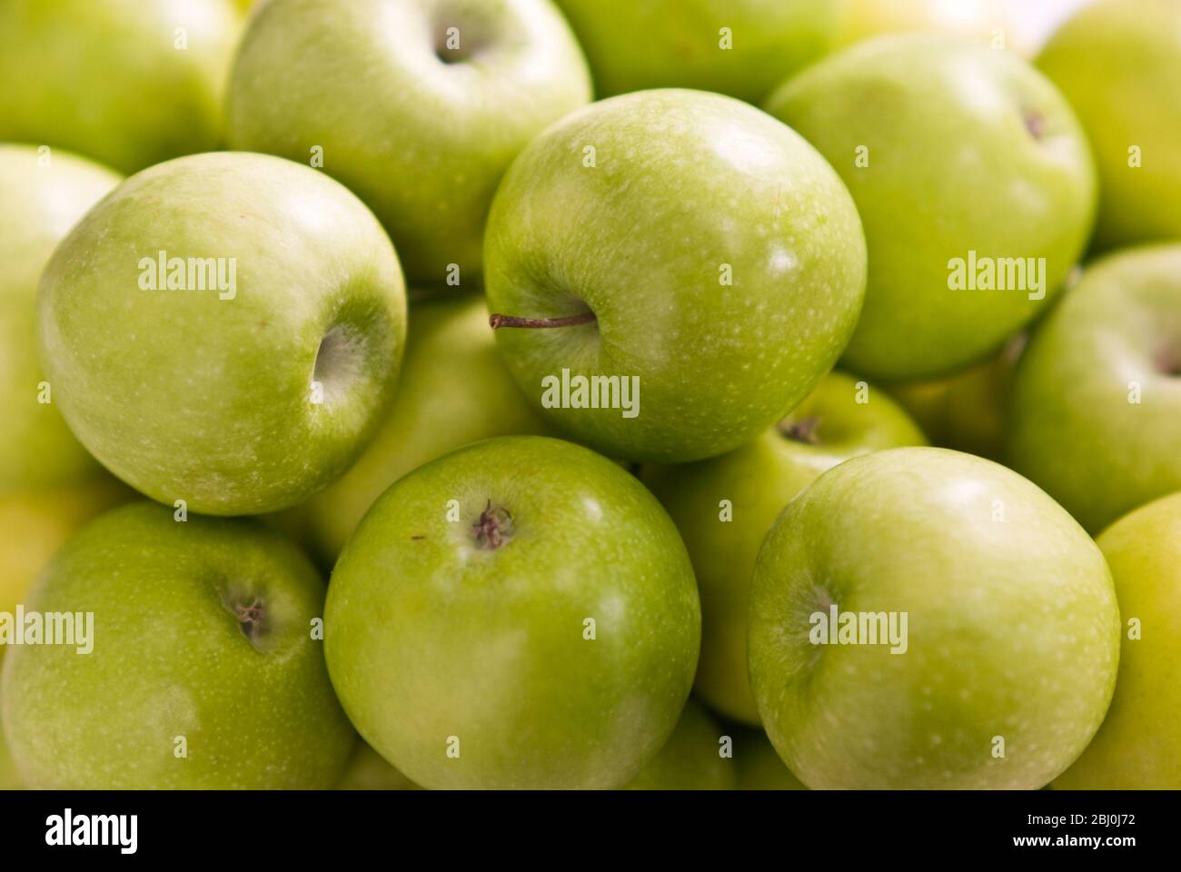 Pommes Granny Smith en masse vert sur fond blanc - Banque D'Images