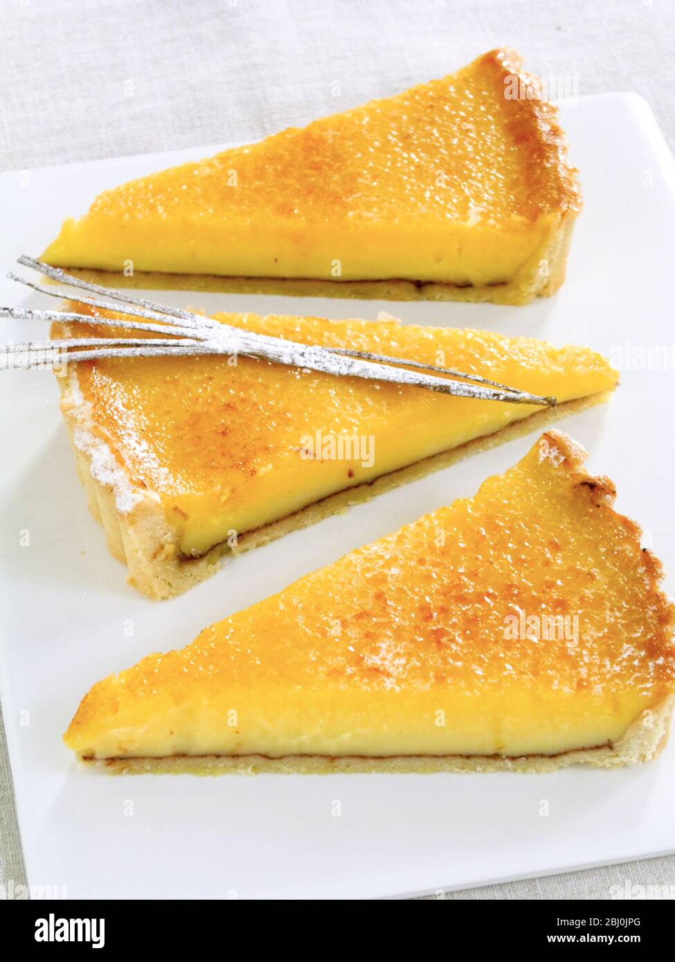 Trois tranches de tarte au citron avec une décoration à la gousse de vanille Banque D'Images