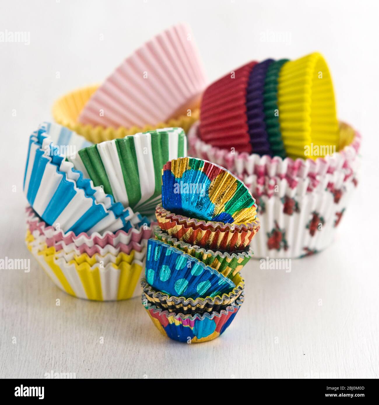 Piles de cartons décoratifs en papier et feuilles de gâteau et muffin - Banque D'Images