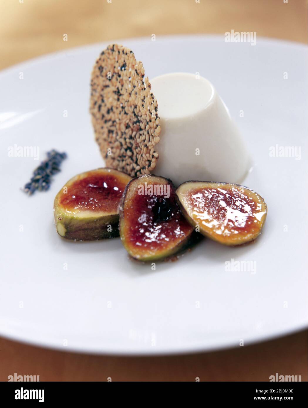 Pannacotta italienne avec biscuit à la lavande et tranches de figue glacés au miel - Banque D'Images