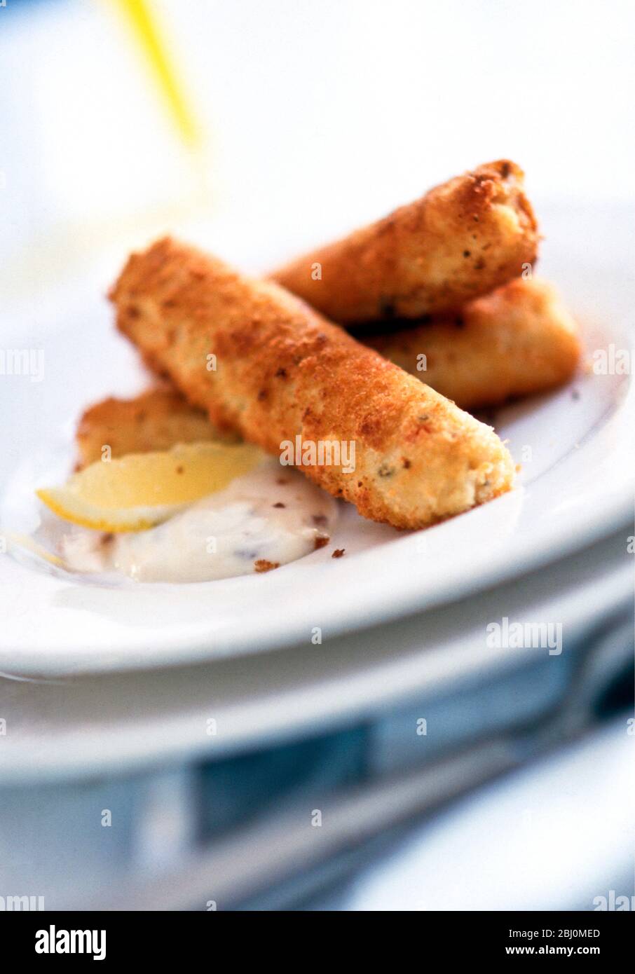 Les bâtonnets de poisson, comme les gâteaux de poisson mais roulés en forme de cigare, à tremper dans du tartare de sauce - Banque D'Images