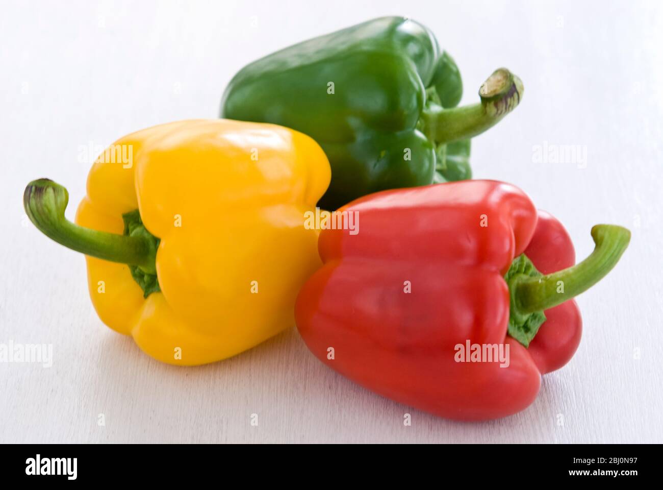 Trois poivrons doux brillants, rouge, vert et jaune - Banque D'Images