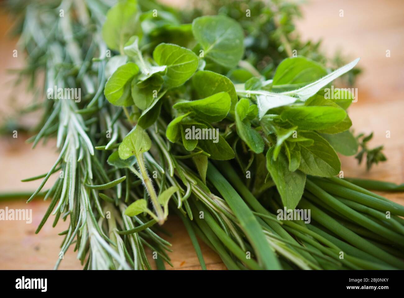 Bouquet d'herbes fraîches mélangées sur planche à découper en bois - Banque D'Images