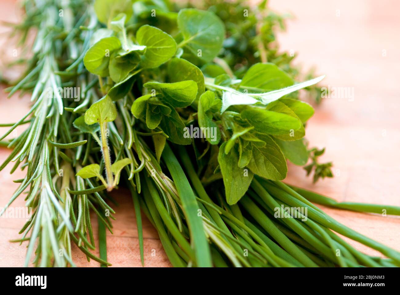 Bouquet d'herbes fraîches mélangées sur planche à découper en bois - Banque D'Images