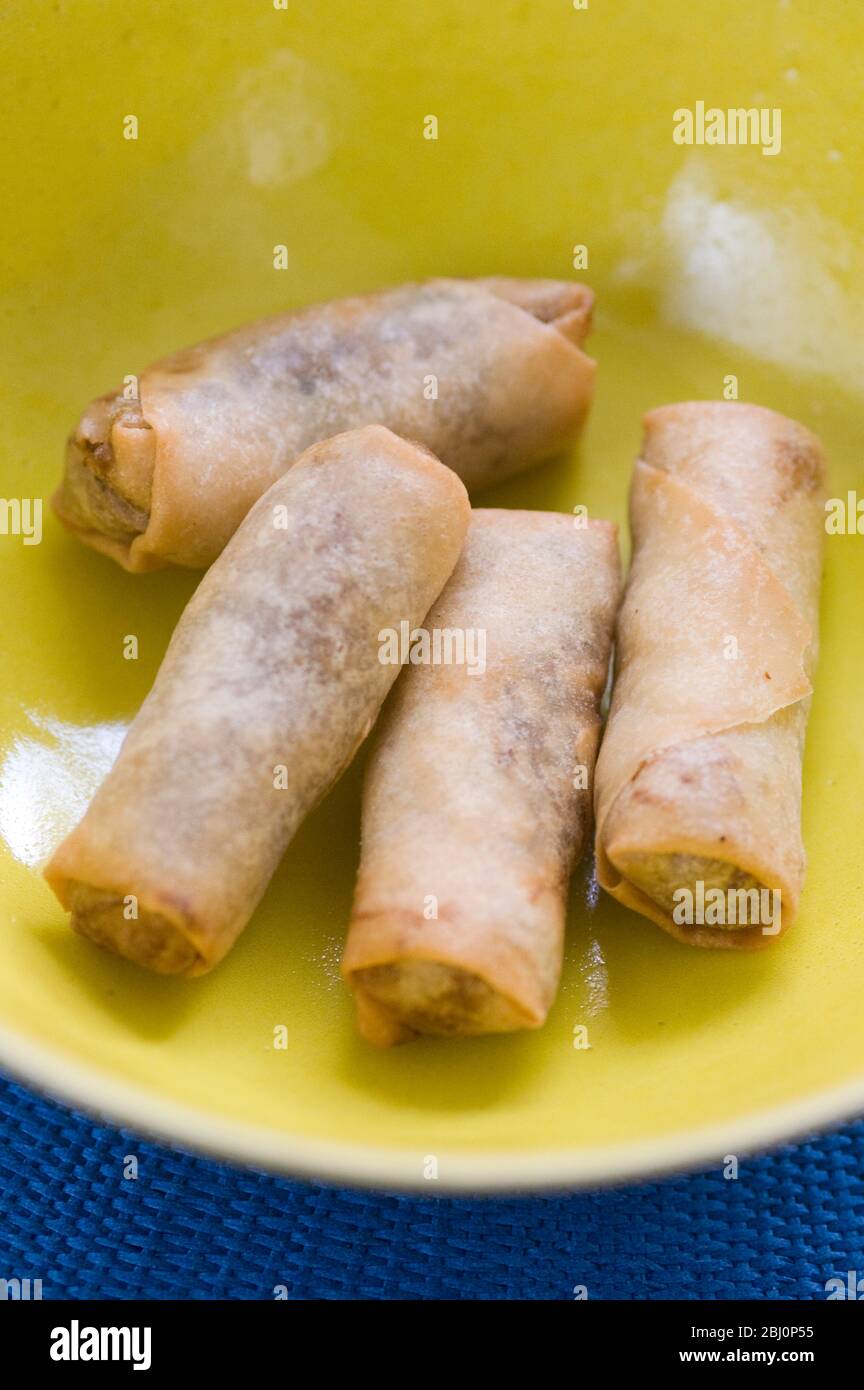 Quatre rouleaux de printemps thaïlandais sur un plat jaune - Banque D'Images