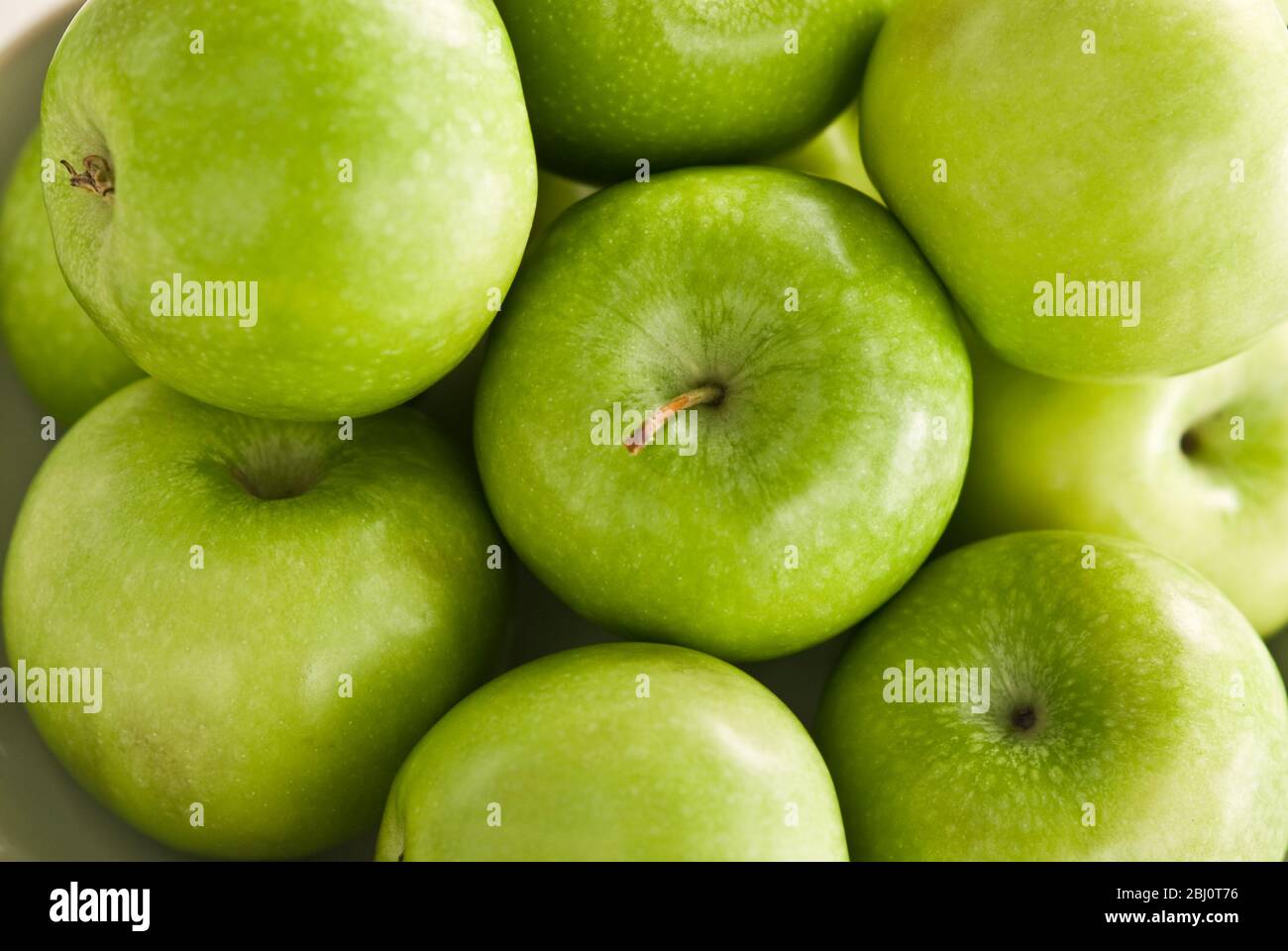 Pommes vertes massées sur fond blanc - Banque D'Images
