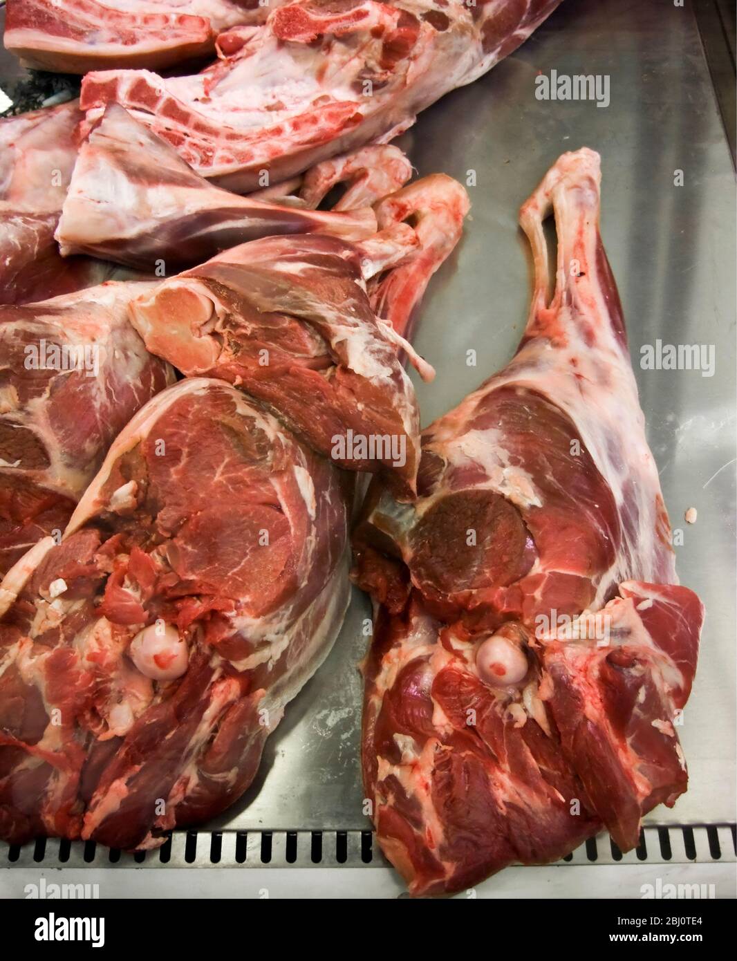 Jambes d'agneau à vendre sur le comptoir du boucher sur le marché couvert de Göteborg, Suède - Banque D'Images
