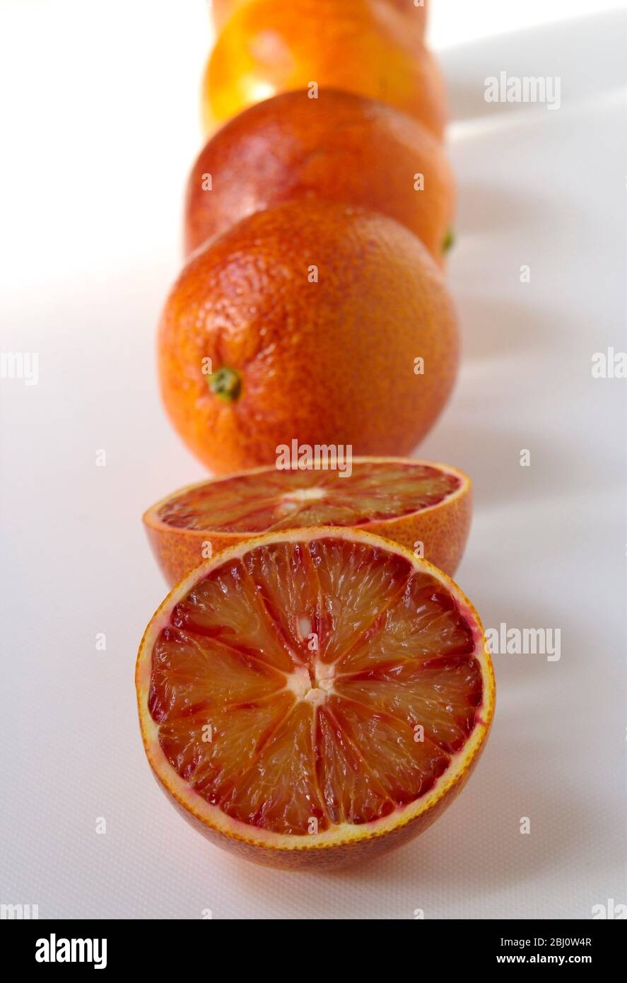 Oranges, coupées et entières sur la surface blanche - Banque D'Images