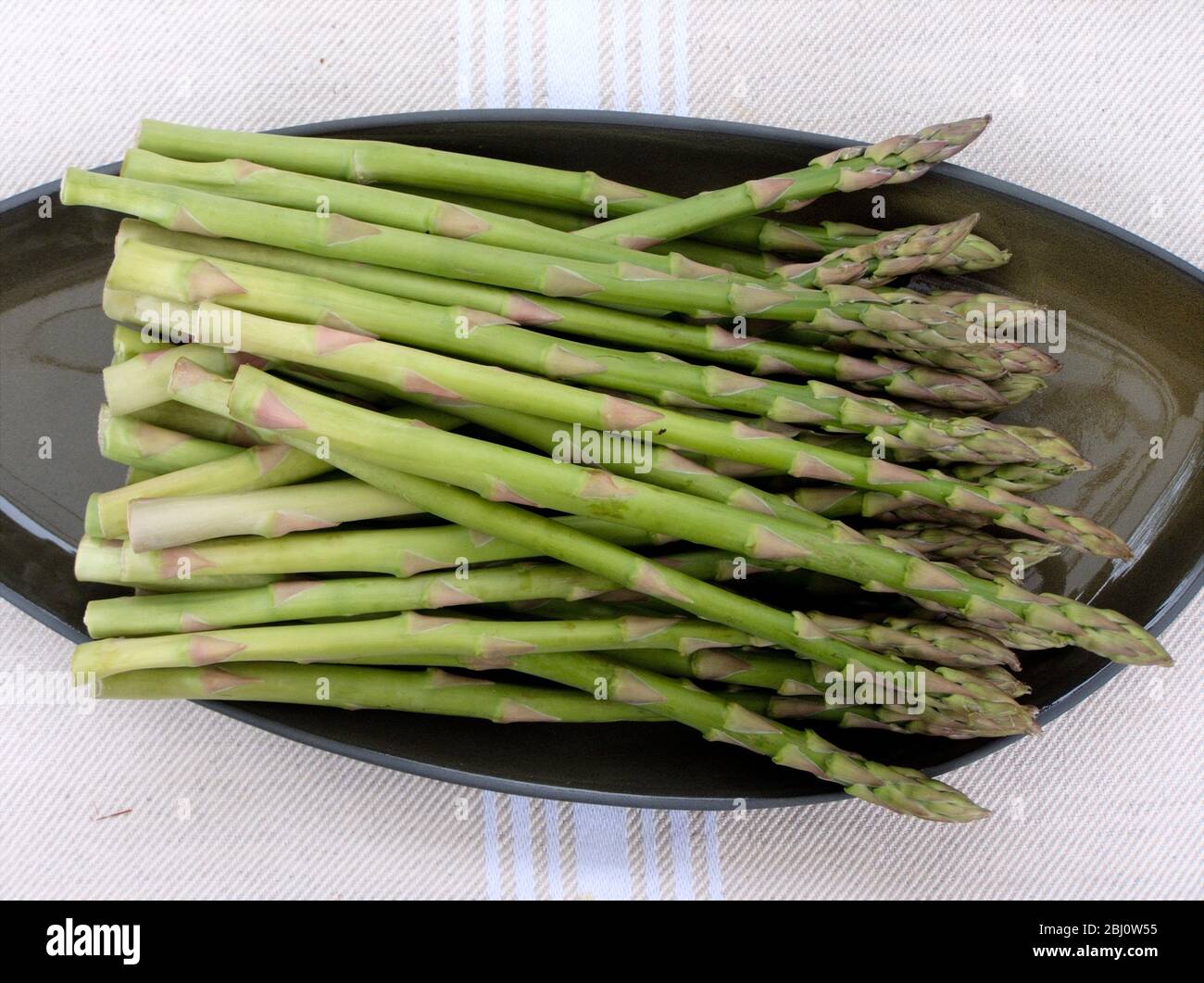 Bouquet d'asperges sur plaque verte - Banque D'Images
