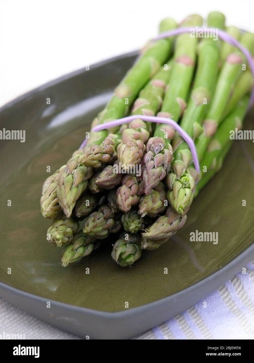 Bouquet d'asperges sur plaque verte - Banque D'Images