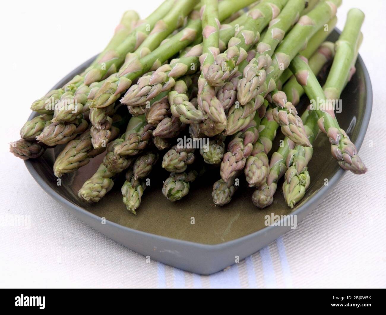 Bouquet d'asperges sur plaque verte - Banque D'Images