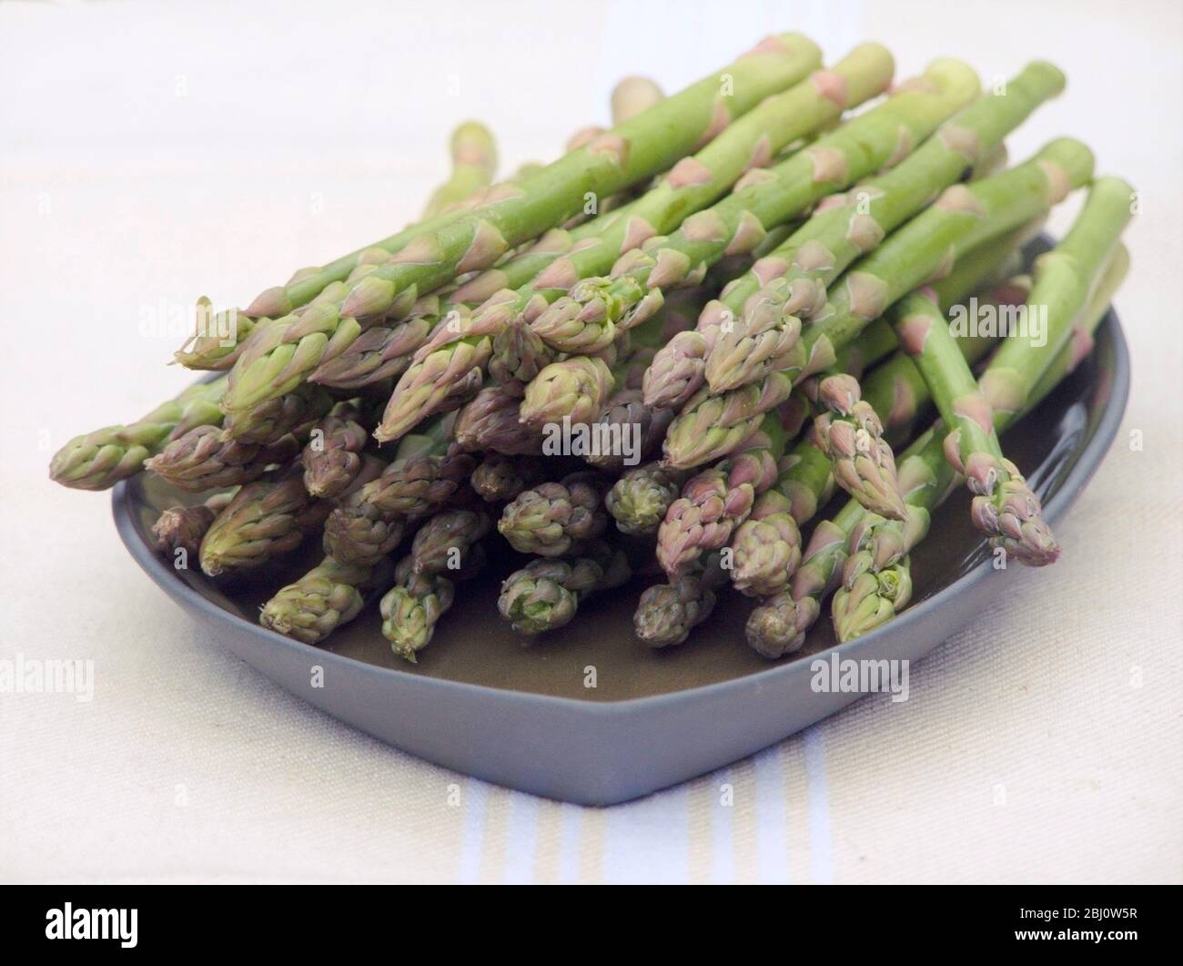 Bouquet d'asperges sur plaque verte - Banque D'Images