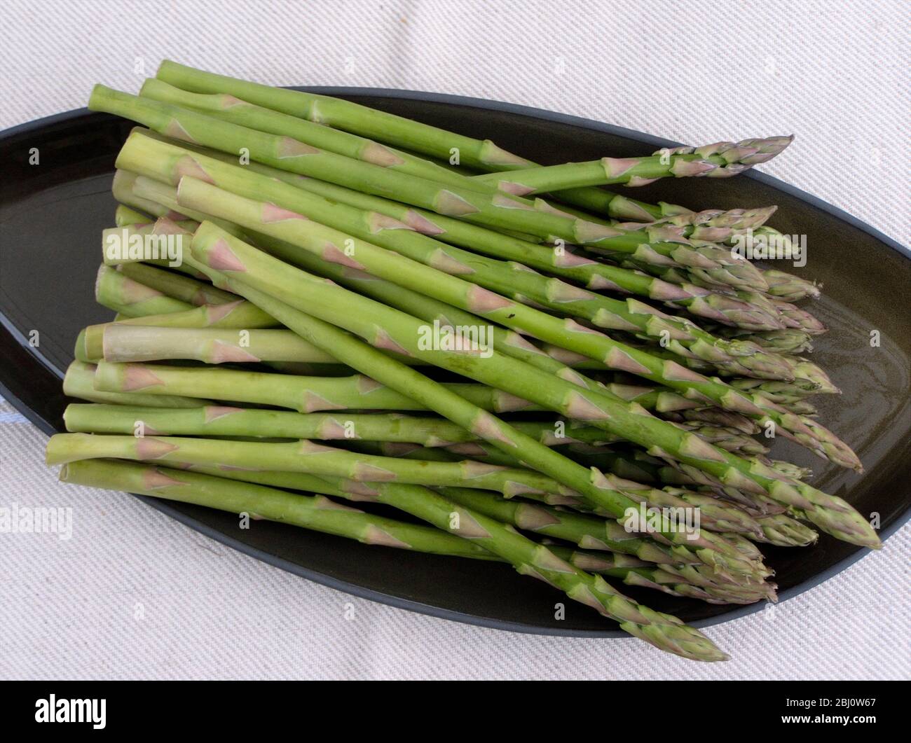 Bouquet d'asperges sur plaque verte - Banque D'Images
