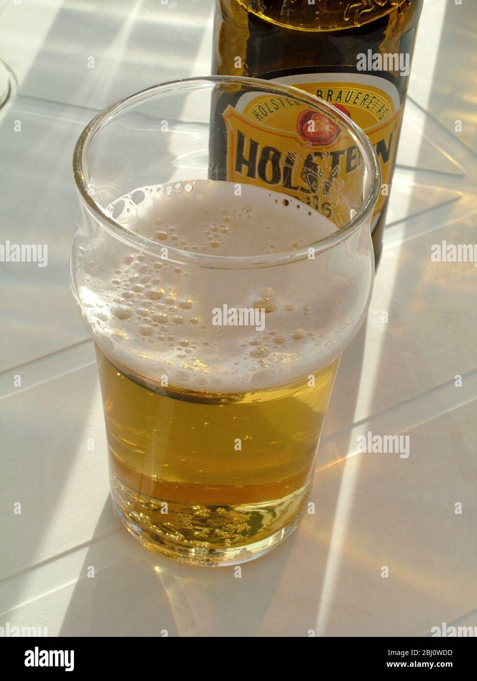 Verre à moitié plein de soleil au café de bord de mer - Banque D'Images