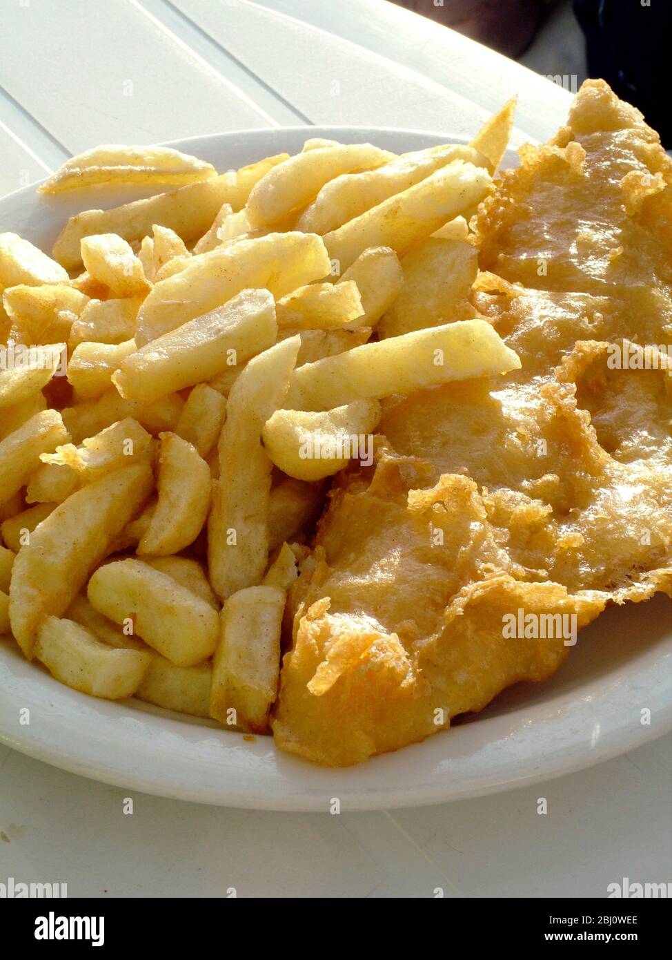 Poisson et chips sur la table du café en bord de mer - Banque D'Images