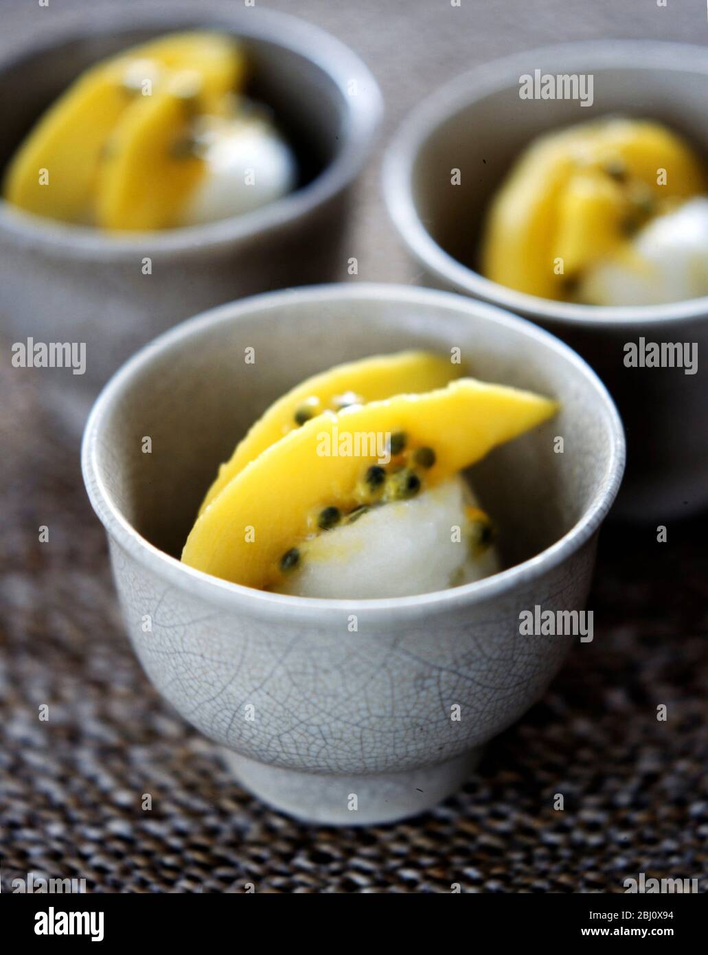 Dessert de sorbet à la citronnelle servi avec de la mangue dans de petits bols gris de pocelain - Banque D'Images