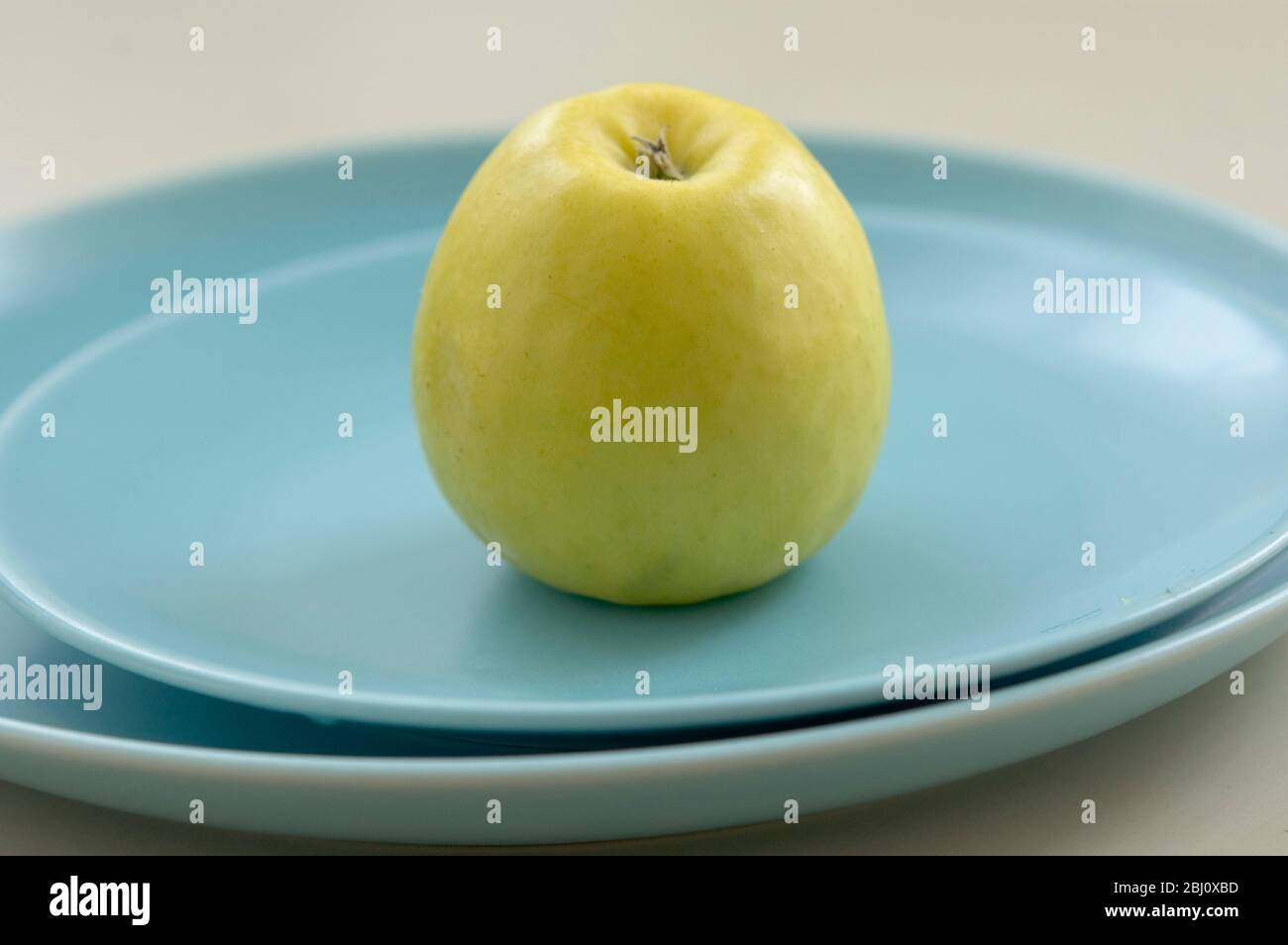 Pomme jaune verte sur plaques bleues - Banque D'Images