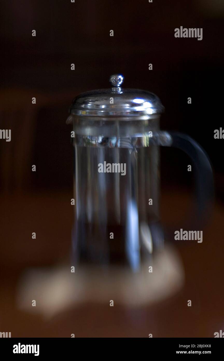 Image floue de la cafetière sur une surface en bois sombre avec fond sombre . Prise de vue avec objectif pour bébés en groupes - Banque D'Images