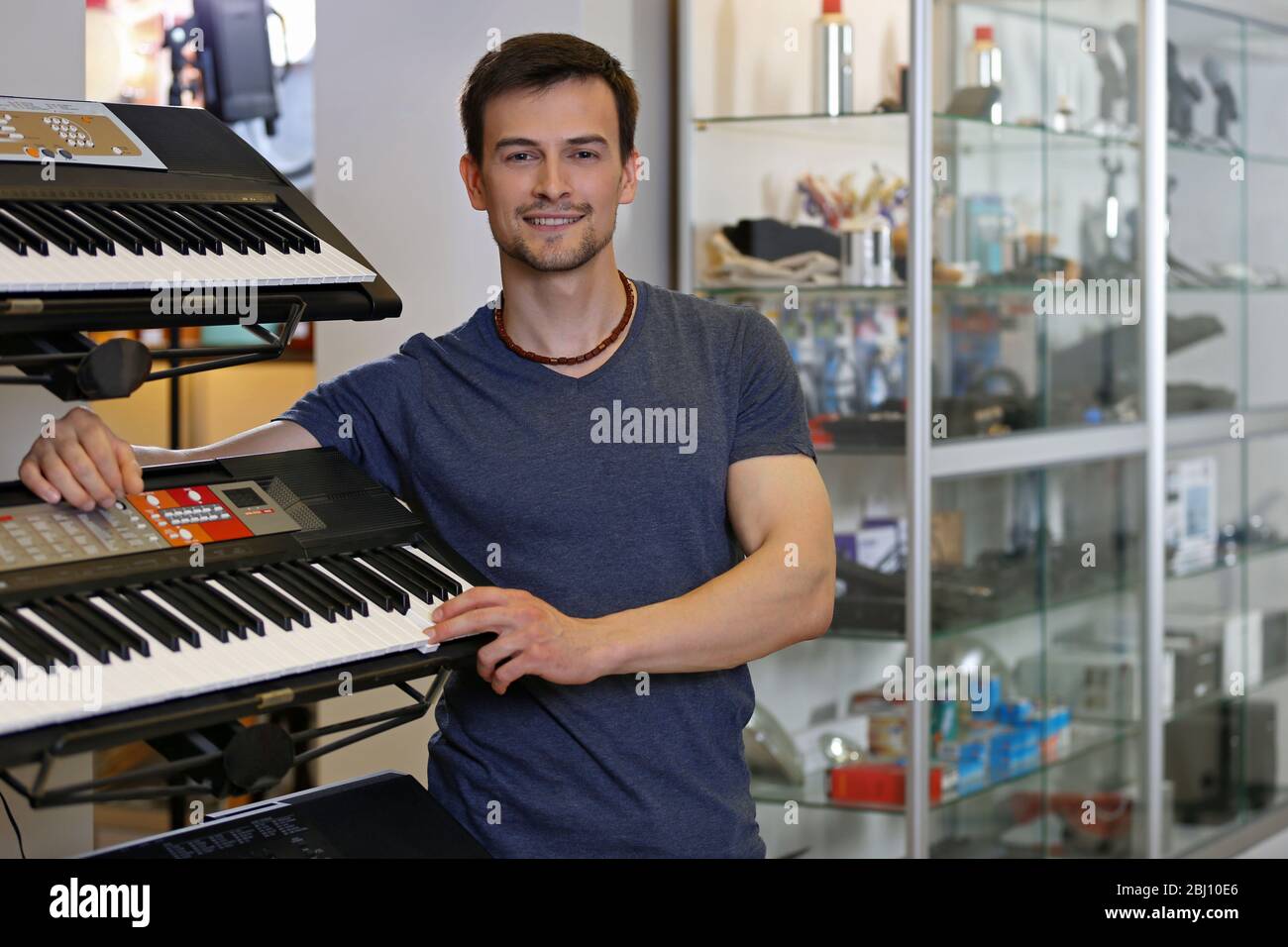 Beau jeune homme dans le magasin de musique Banque D'Images