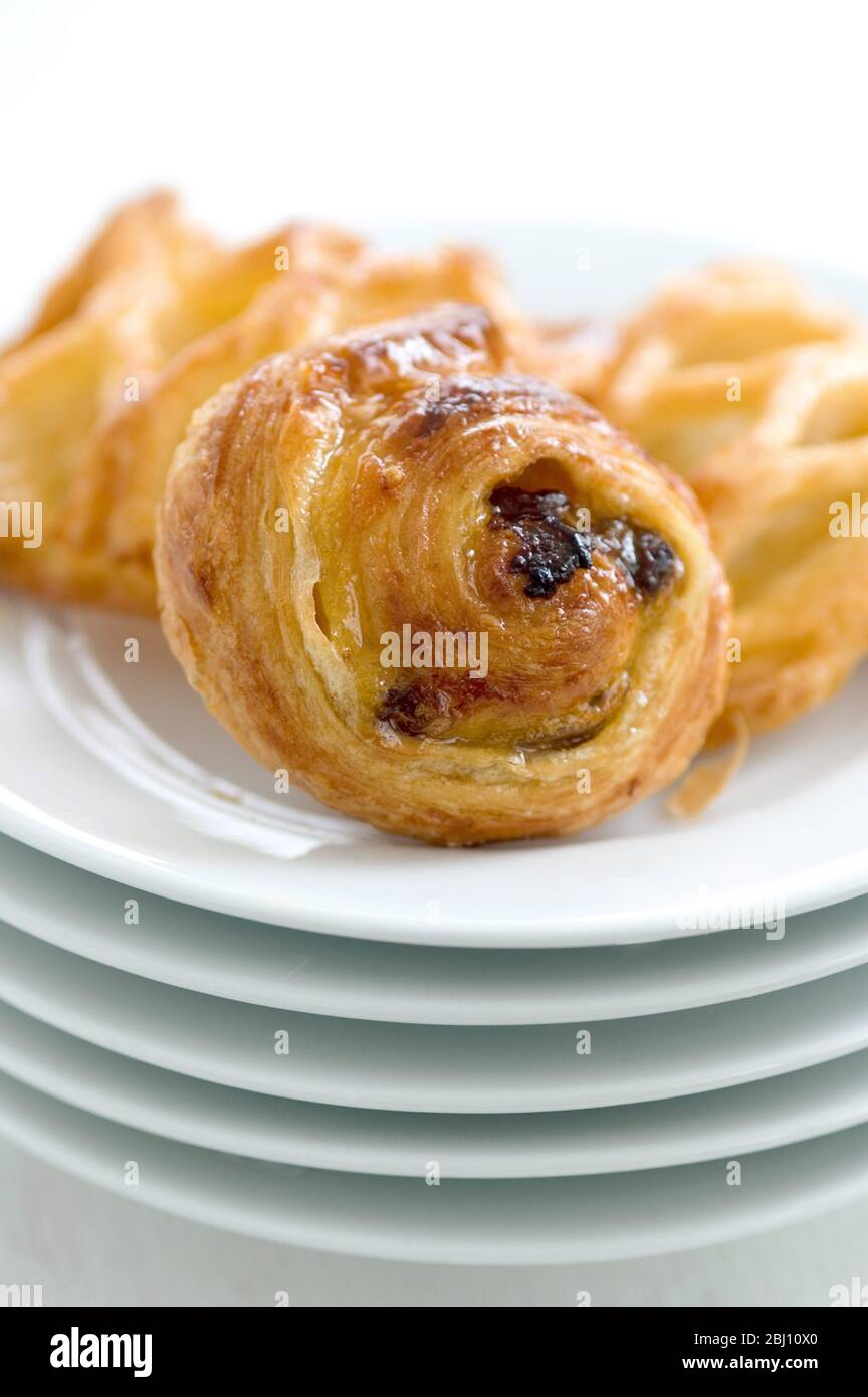 Petites pâtisseries danoises sur une pile de plaques blanches - Banque D'Images