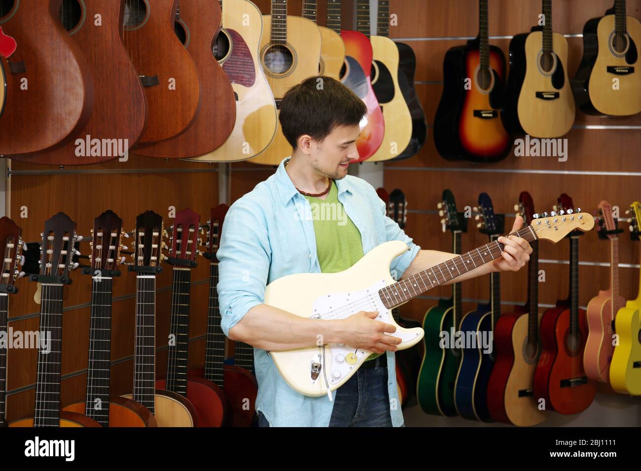 Beau jeune homme dans le magasin de musique Banque D'Images