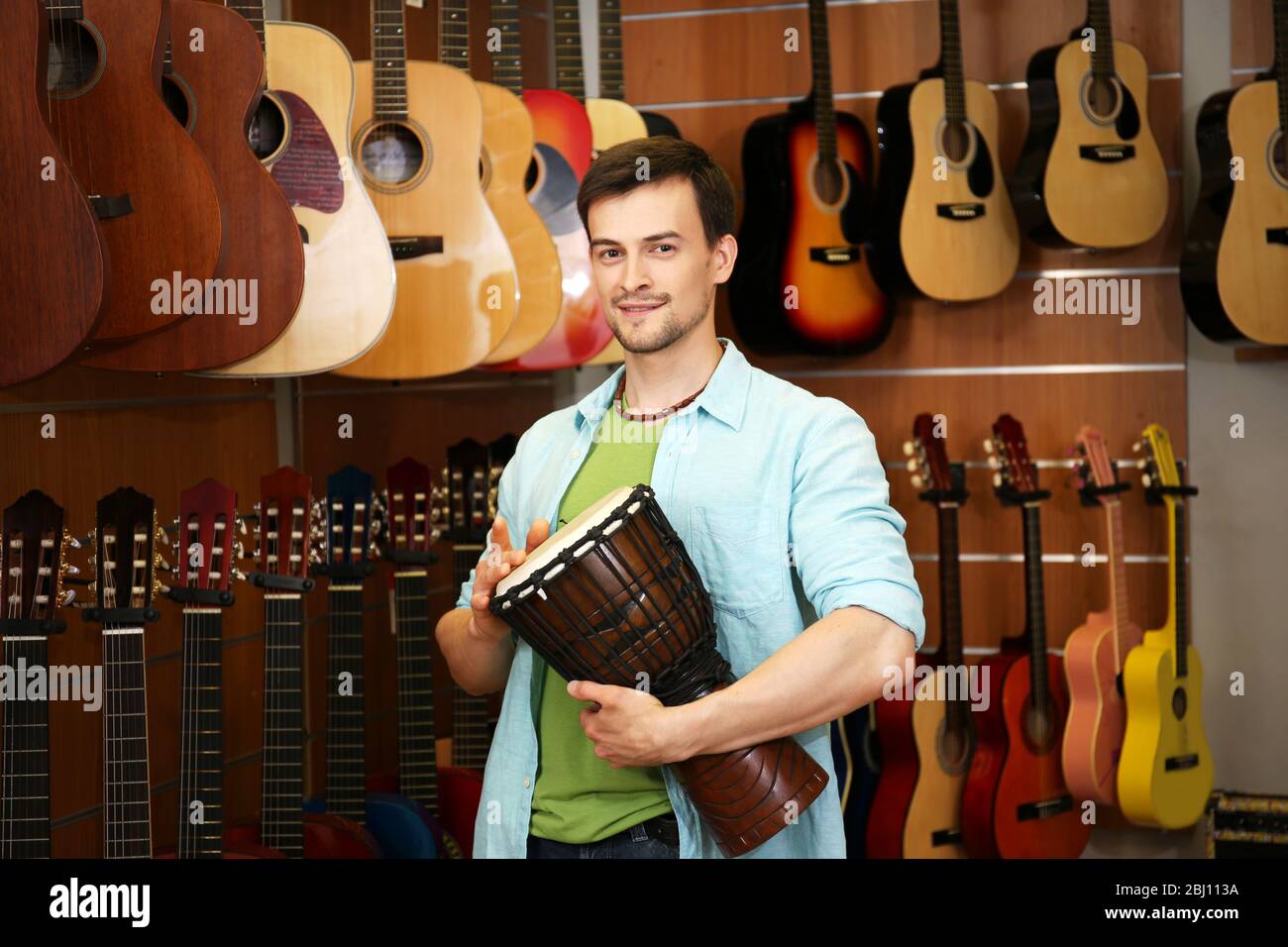 Beau jeune homme dans le magasin de musique Banque D'Images