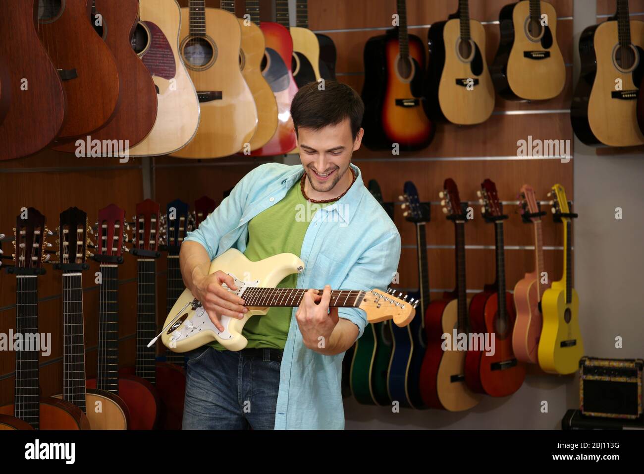 Beau jeune homme dans le magasin de musique Banque D'Images