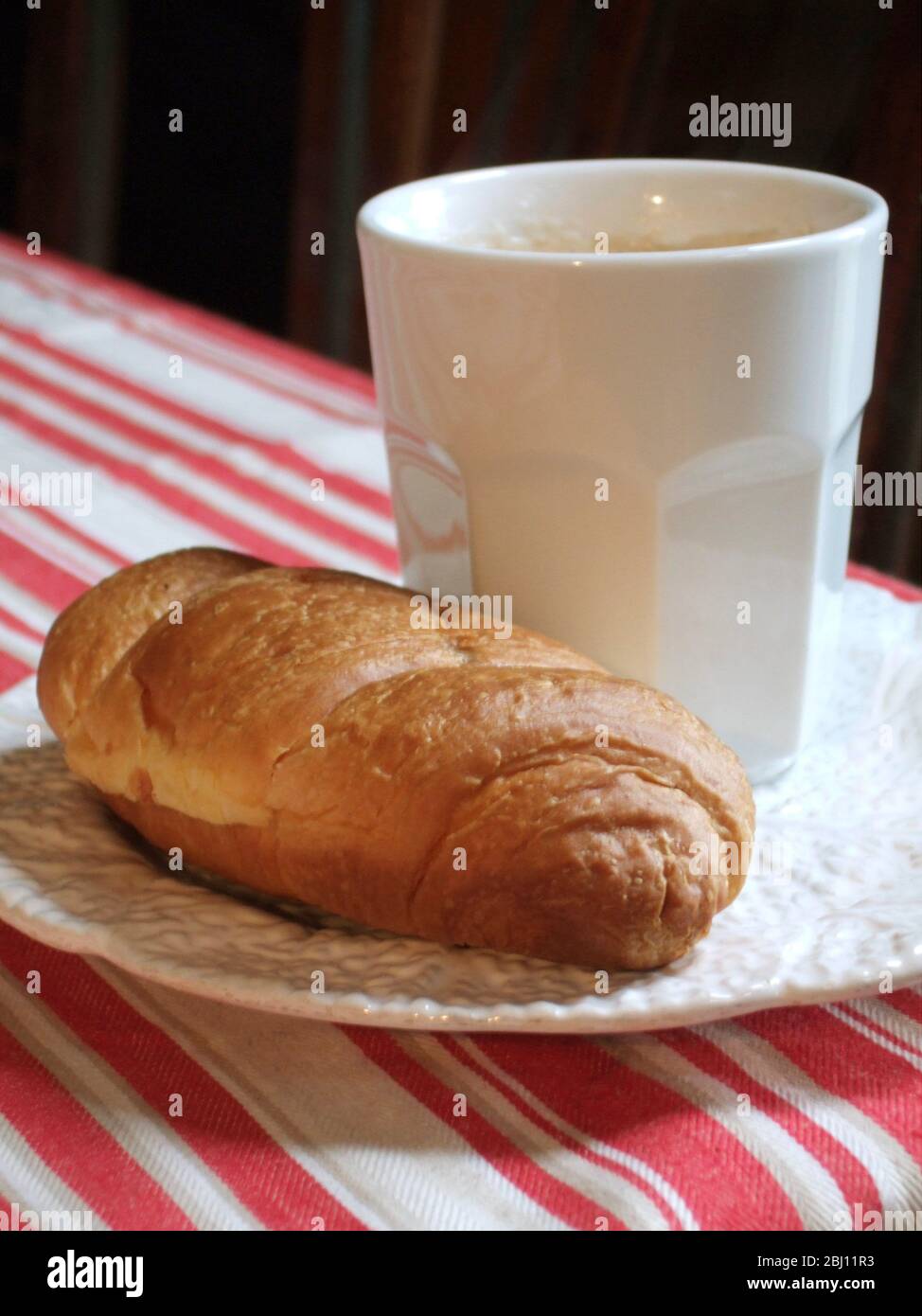 Tasse de café blanche sur plaque avec croissant - Banque D'Images