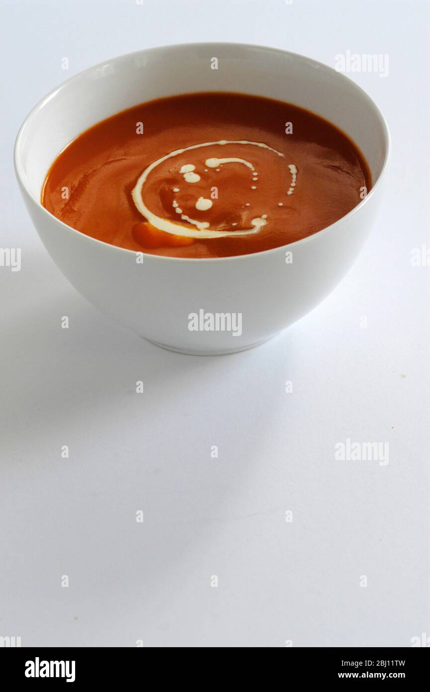 Bol blanc de soupe de tomate avec tourbillon de crème - Banque D'Images