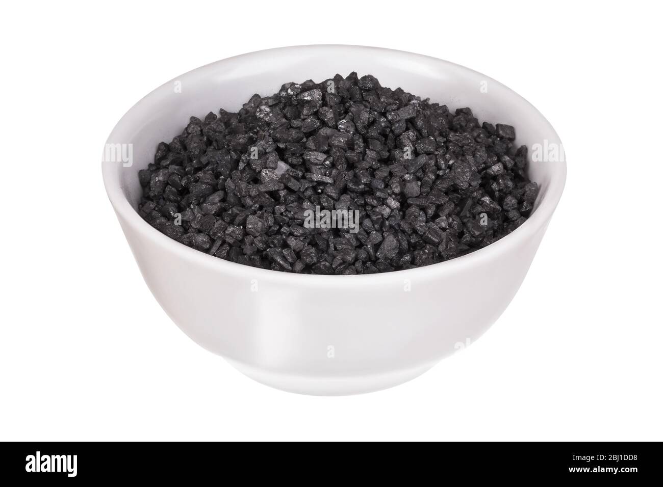 Sel noir grossier dans un bol isolé sur fond blanc. Sel de lave hawaïen. Sel de roche noire himalayenne. Le sel de jeudi. Banque D'Images
