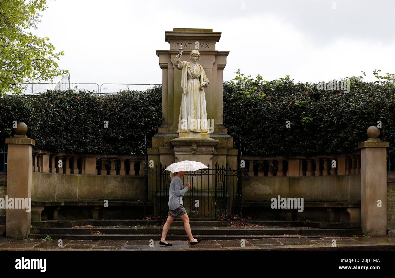 Derby, Derbyshire, Royaume-Uni. 28 avril 2020. Une femme passe devant une statue de Florence Nightingale après que la nation ait observé un silence de minuteÕs pour se souvenir des travailleurs clés morts à cause de Covid-19 pendant le verrouillage de la pandémie de coronavirus. Credit Darren Staples/Alay Live News. Banque D'Images