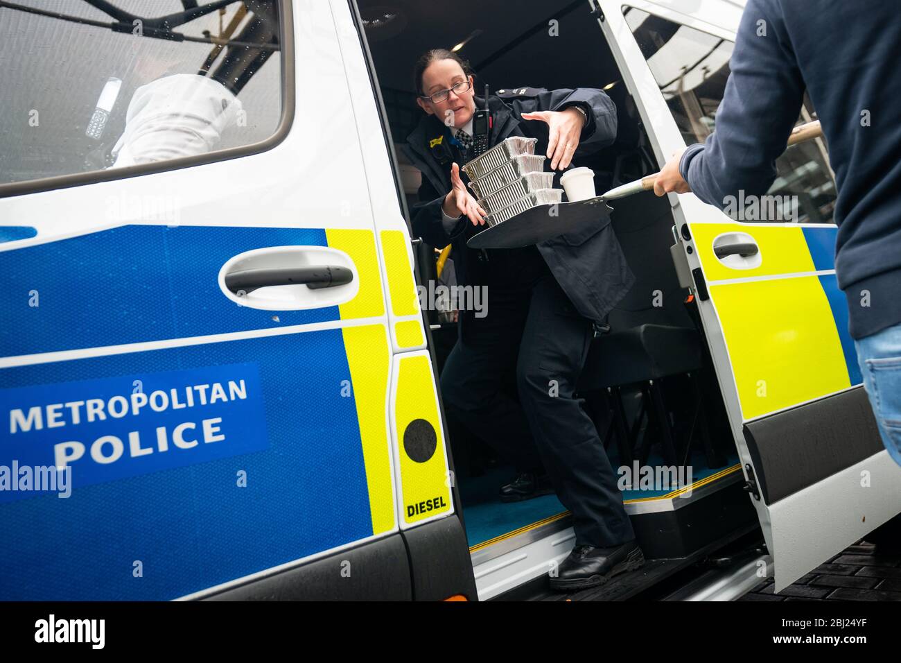 La nourriture et les boissons sont transmises dans un minibus de police, à un passage gratuit pour les services d'urgence à l'hôtel Berkeley alors que le Royaume-Uni continue à se verrouiller pour aider à freiner la propagation du coronavirus. Banque D'Images