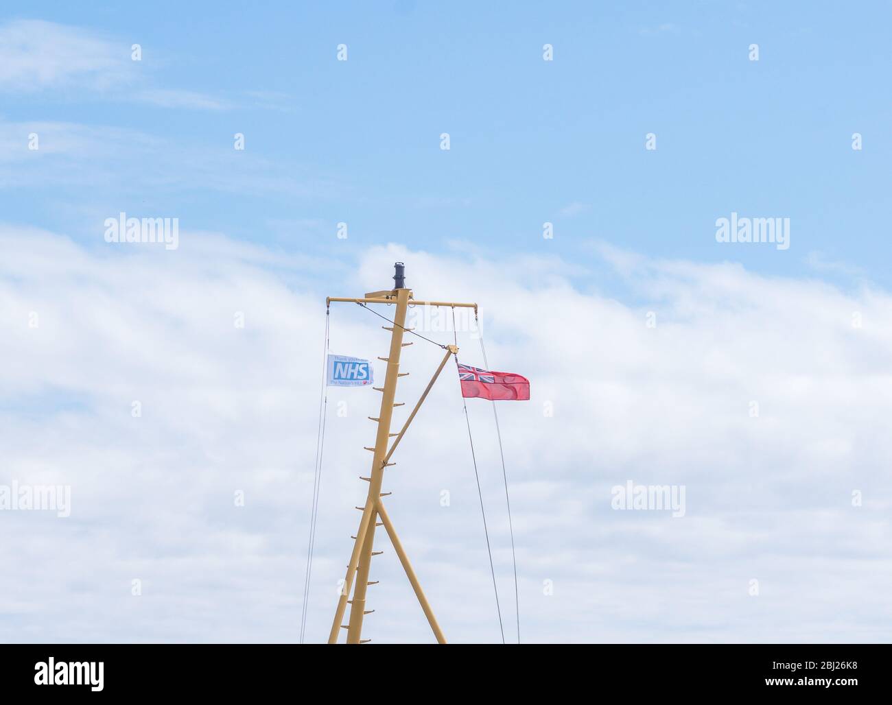 NHS, le drapeau des héros de remerciement, avec panneau rouge endévolant sur mât sur le seigneur de ferry Calmac des îles dans les Hébrides extérieures de l'Uist du Sud, Ecosse Banque D'Images