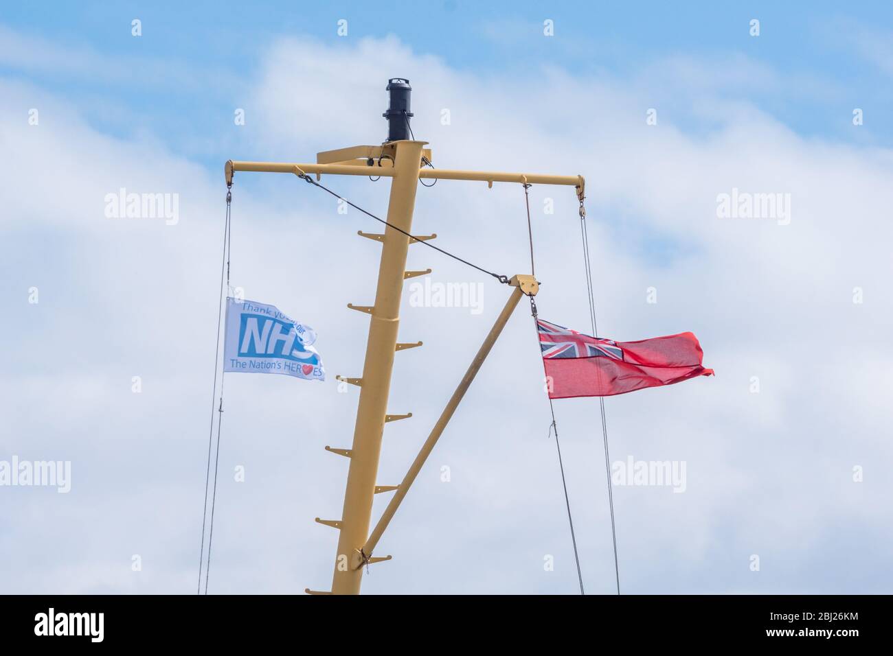 NHS, le drapeau des héros de remerciement, avec panneau rouge endévolant sur mât sur le seigneur de ferry Calmac des îles dans les Hébrides extérieures de l'Uist du Sud, Ecosse Banque D'Images