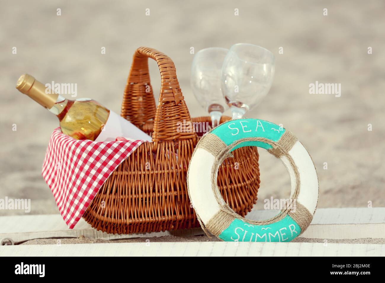 Panier pique-nique avec bouteille de vin sur plage de sable Banque D'Images