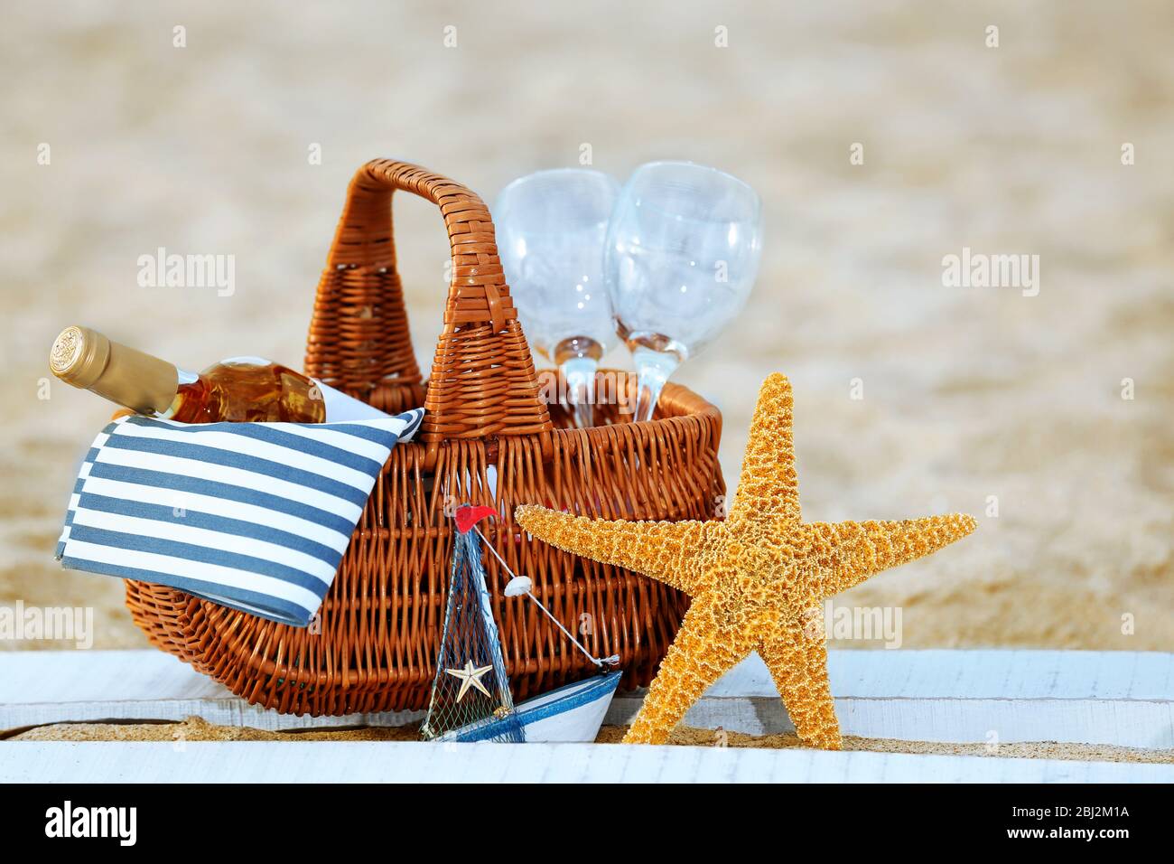 Panier pique-nique avec bouteille de vin sur plage de sable Banque D'Images