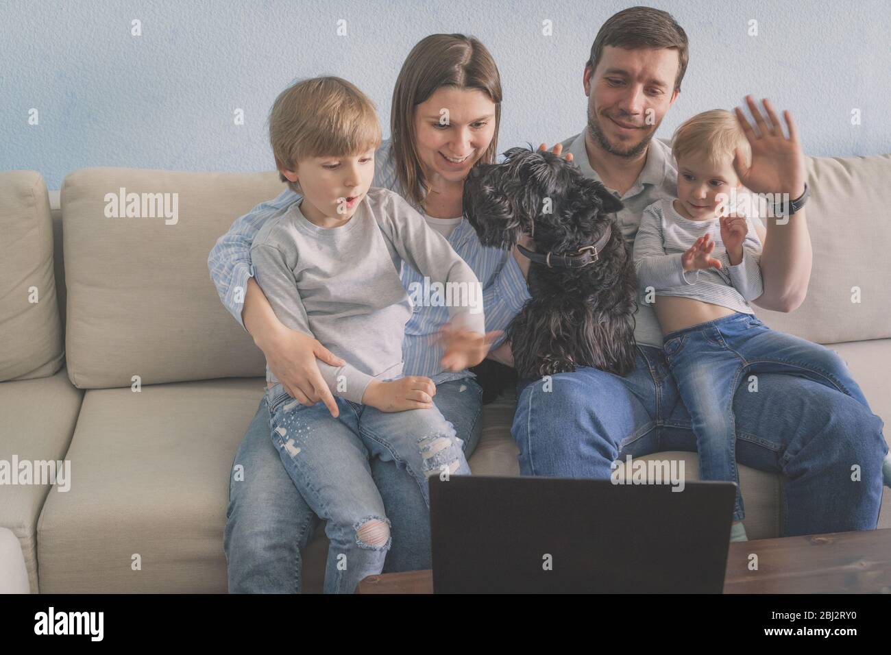 La famille effectue un appel vidéo depuis sa maison Banque D'Images