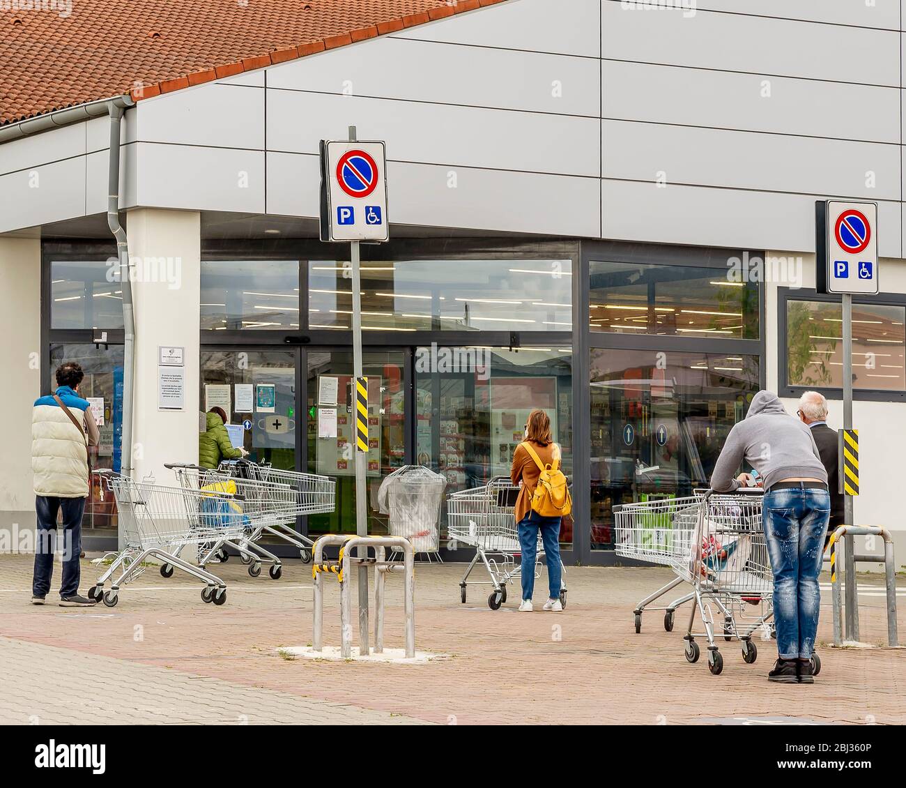 Les personnes avec masques de protection faisant la queue devant un supermarché en raison du coronavirus Covid-19 qui oblige les clients à faire des entrées sur quota Banque D'Images