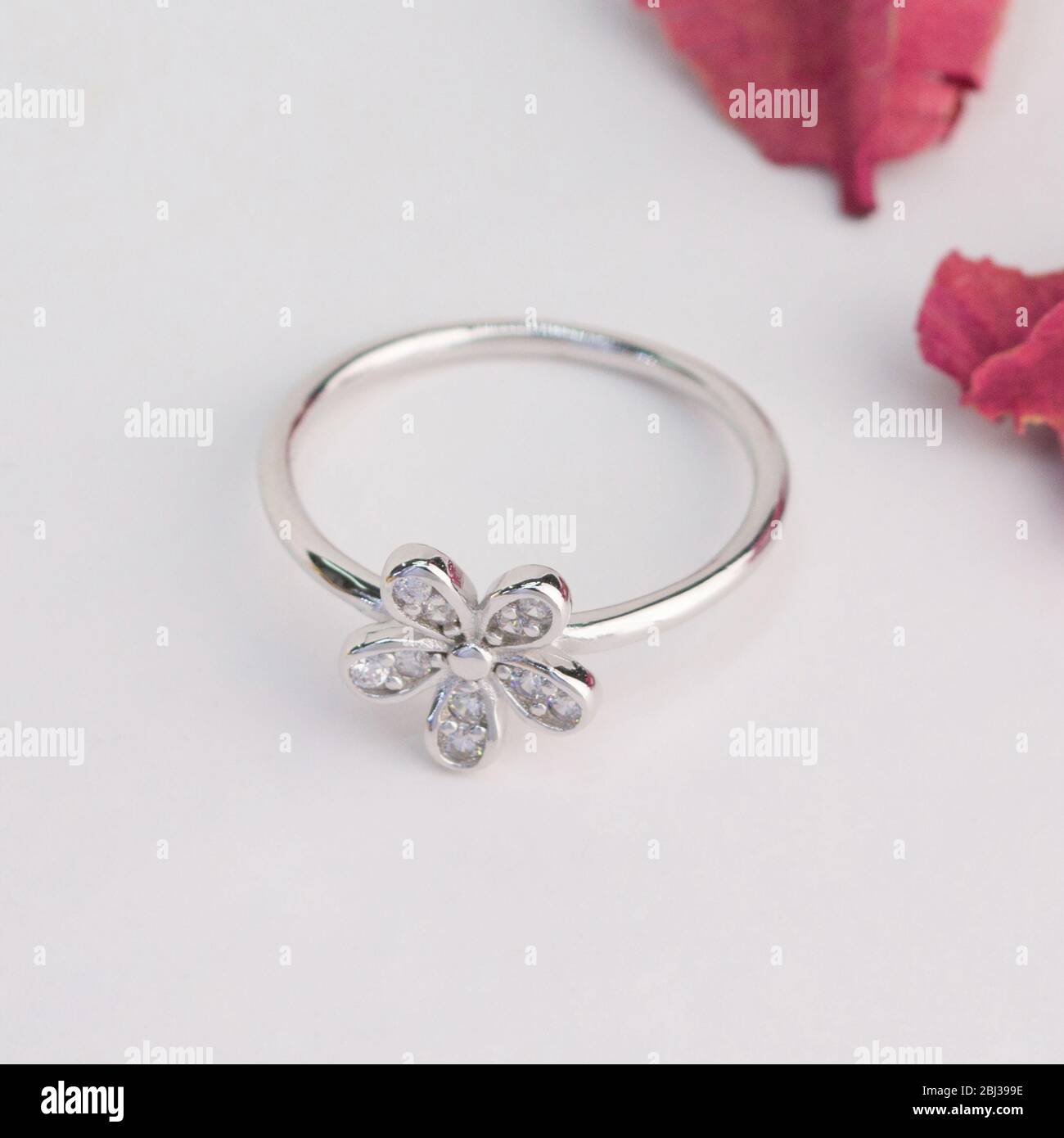 bague argentée en forme de fleur décorée avec du diamant isolé sur fond blanc Banque D'Images