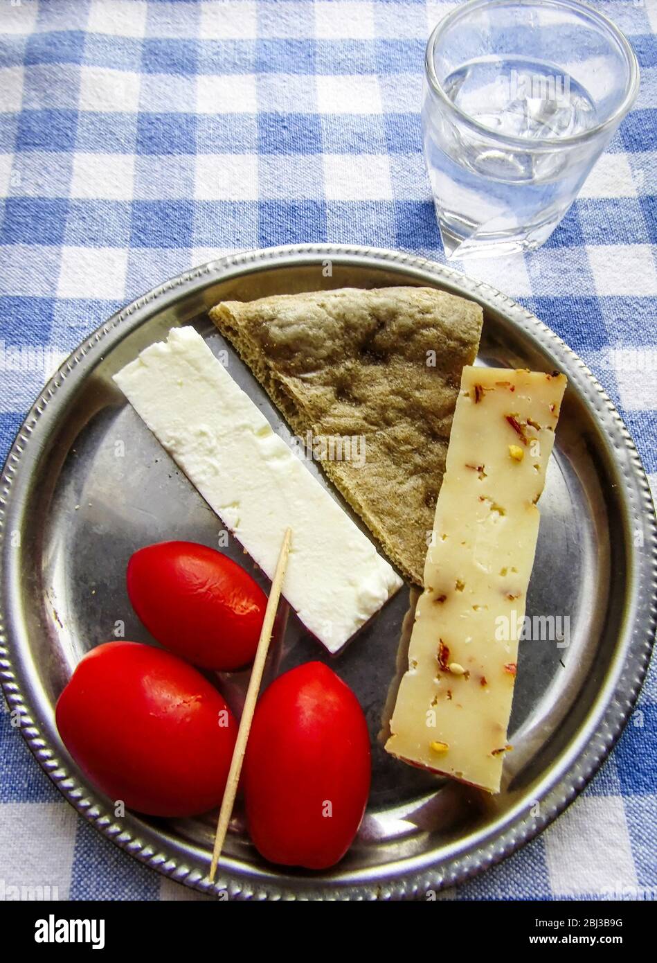 Meze de Feta et de Graviera Cheese, tomates, pain de Pita, avec un verre de Tsikoudia, Raki. Crète, Grèce Banque D'Images