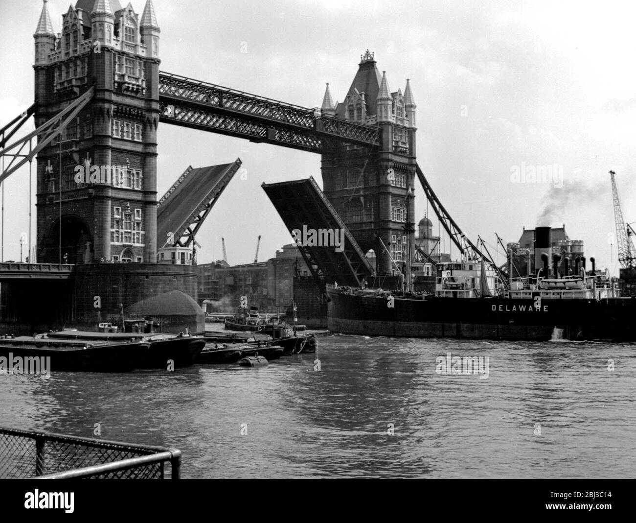 Un navire marchand appelé le Delaware passe sous Tower Bridge à Londres alors que la portée du pont est élevée dans les années 1950 Banque D'Images
