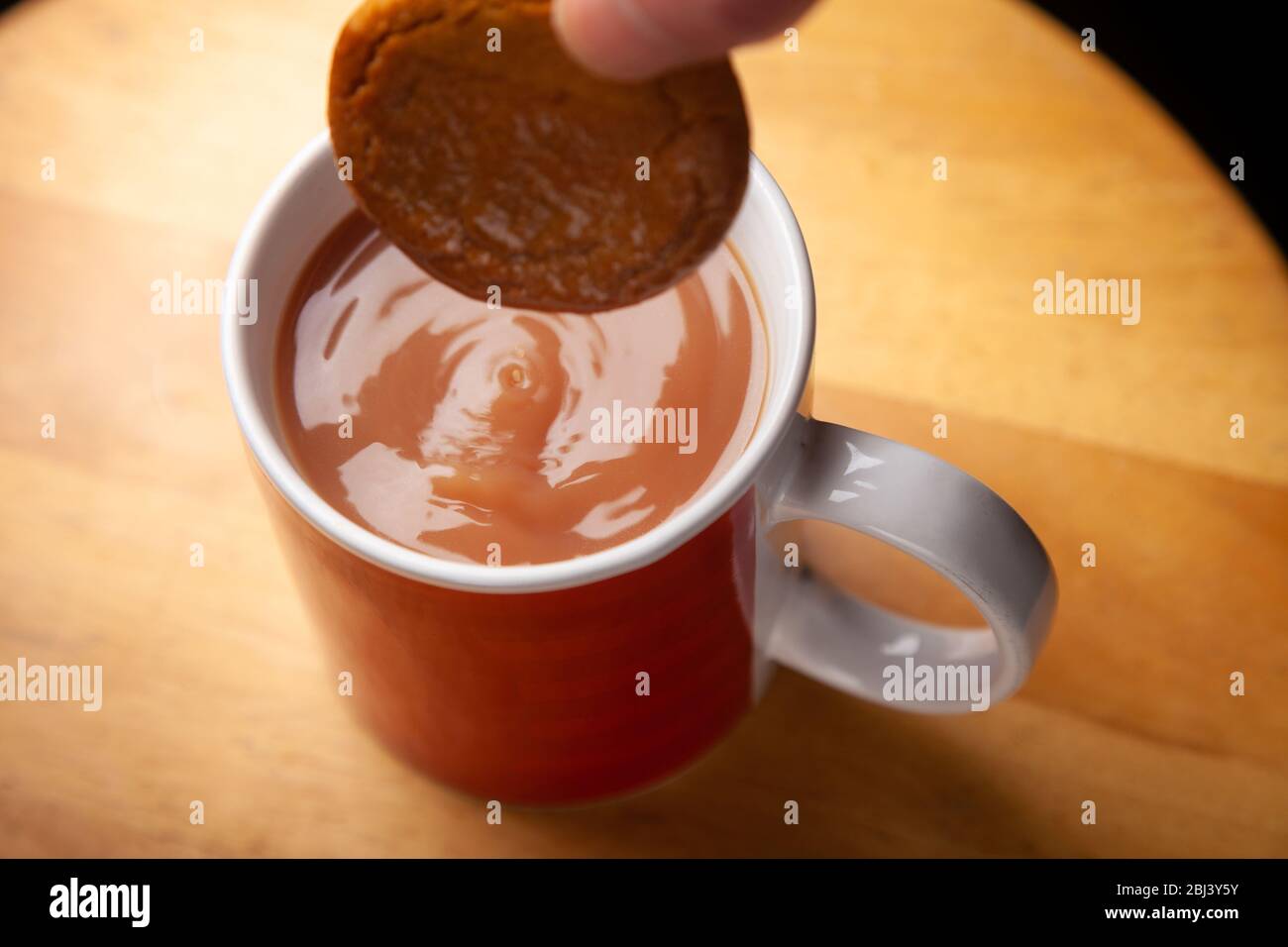 Douchez un biscuit au gingembre dans un mug à thé Banque D'Images