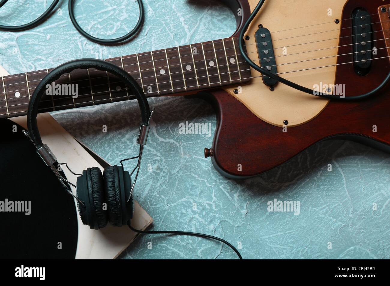 Guitare électrique et casque avec accessoires de musique sur fond gris Banque D'Images