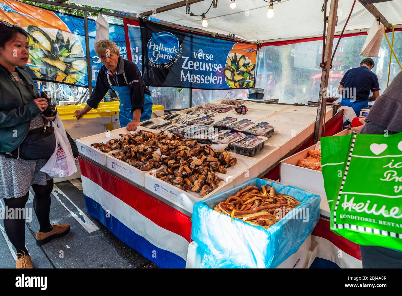 Amsterdam, Pays-Bas - 8 septembre 2018 : vendeur dans une boutique de poissons et fruits de mer avec des gens autour du marché Albert Cuyp, marché de rue à Amsterdam, ne Banque D'Images